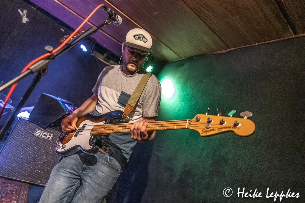 Sören Dieden von Kip Kasper spielt live im Wild Rover Aachen E-Bass auf der Bühne – mit Verstärker und Mikrofon.