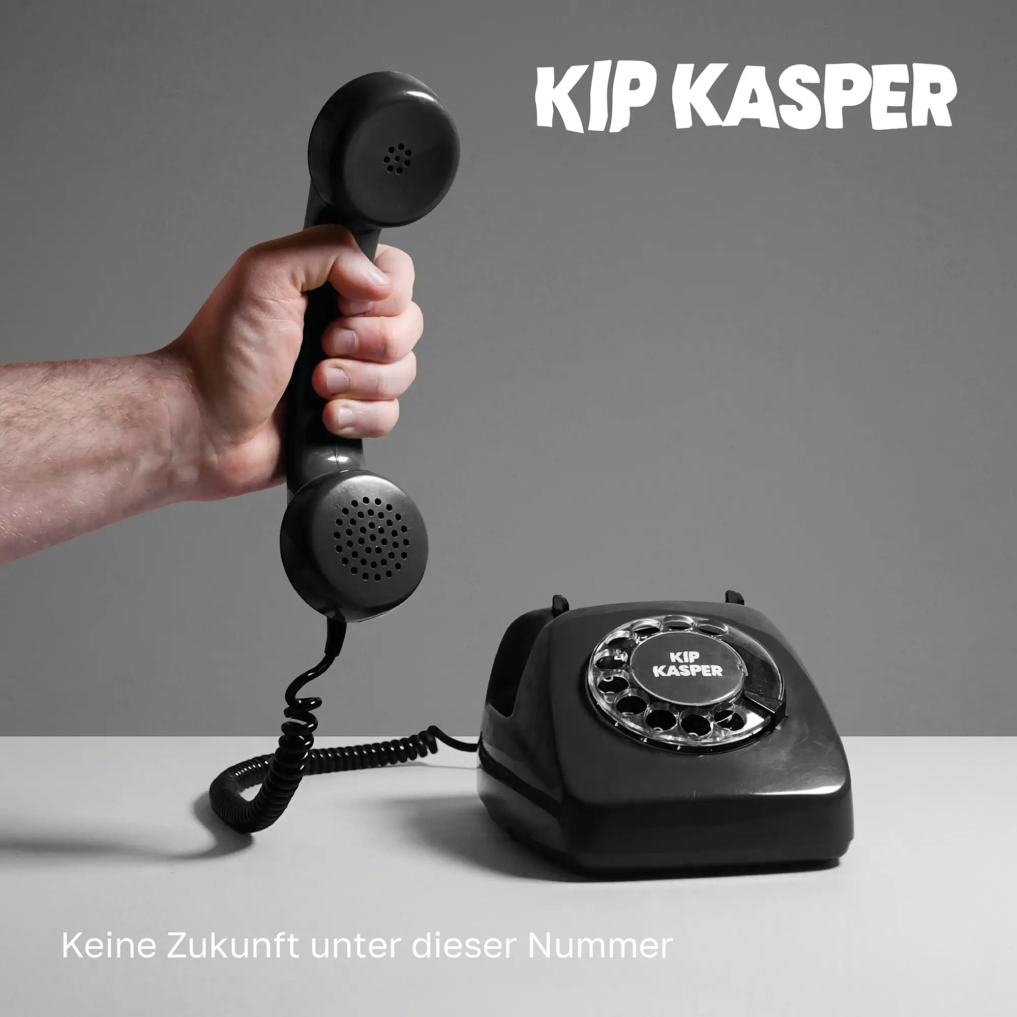 Albumcover von 'Keine Zukunft unter dieser Nummer' von Kip Kasper – ein altes schwarzes Wählscheibentelefon vor grauem Hintergrund, der Hörer wird von einer Hand im Anschnitt gehalten.