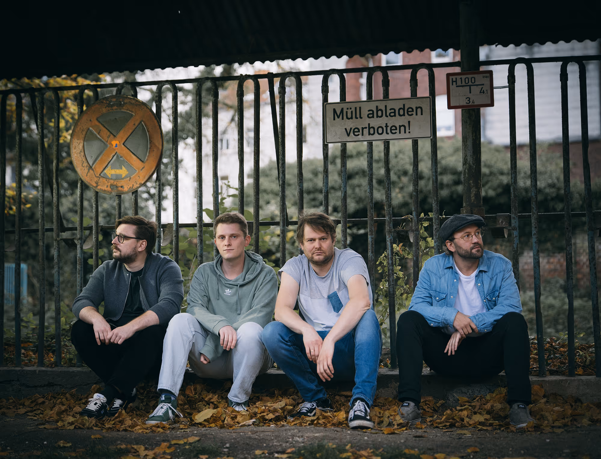 KIP KASPER — alle vier Bandmitglieder sitzen für ein Gruppenportrait vor einem Zaun.